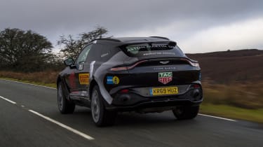 Aston Martin DBX prototype driving on road - rear view