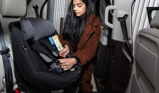 Lady putting ISOFIX child seat in car