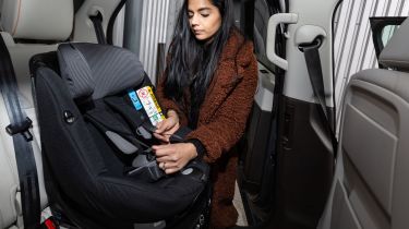 Lady putting ISOFIX child seat in car