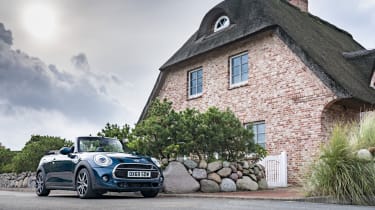 MINI Sidewalk Convertible parked next to cottage with roof down