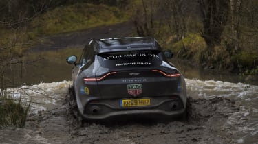 Aston Martin DBX prototype wading through puddle - rear view