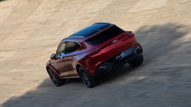 Aston Martin DBX driving on banked circuit - rear