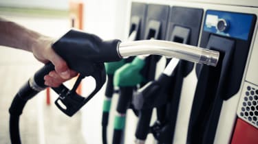 A customer picking up a diesel fuel pump at a filling station