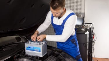 Man putting battery in car