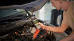 Man checking the charge of a car battery